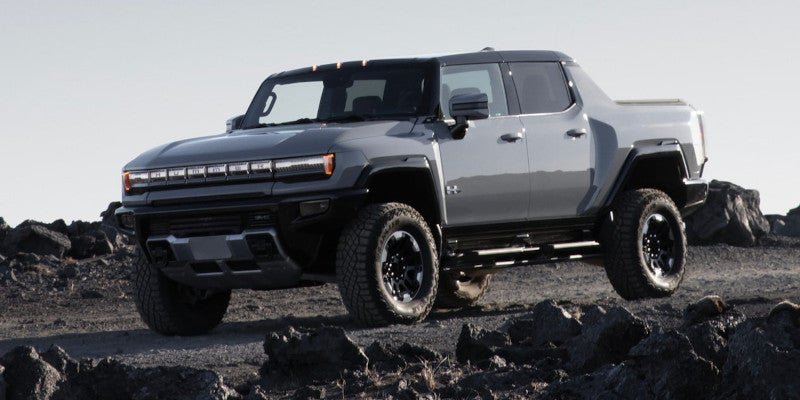 Front-side view of Hummer EV pickup driving on rocky terrain