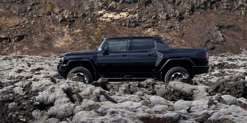 Side profile of Hummer EV pickup on rocky ground