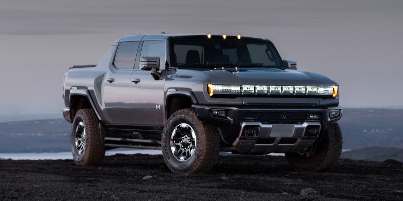 Hummer EV pickup parked on rugged landscape at dusk