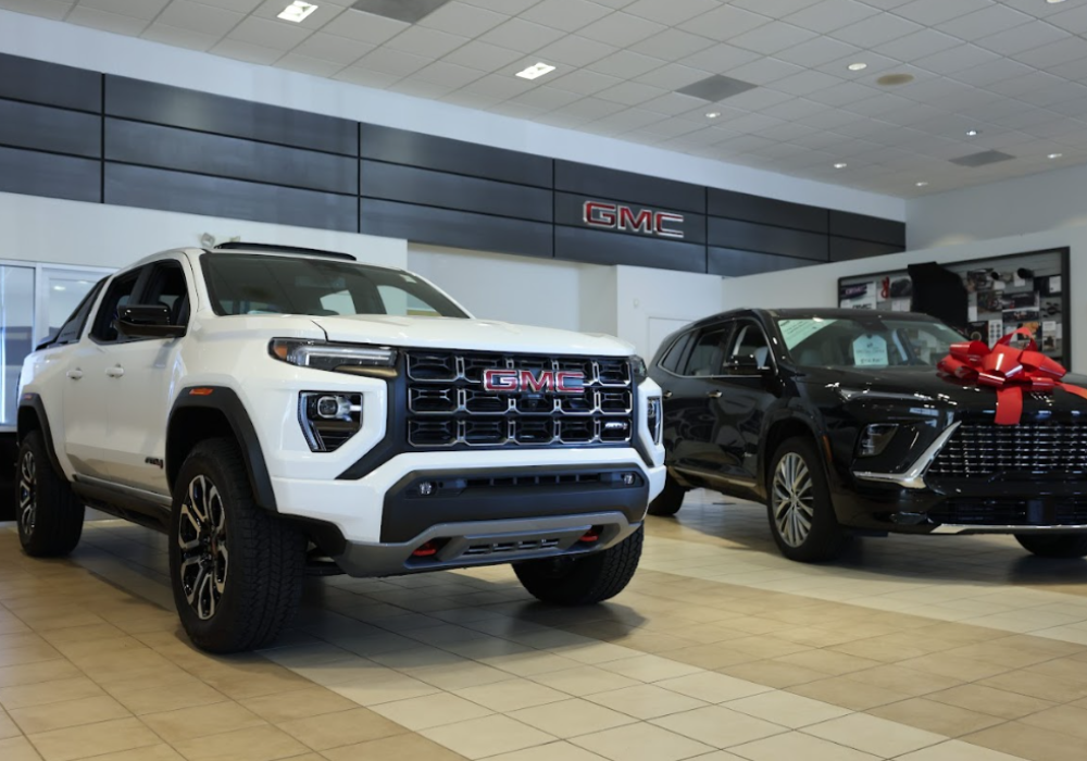 Two GMC and Buick SUVs parked inside the Flow Buick GMC of Winston-Salem showroom
