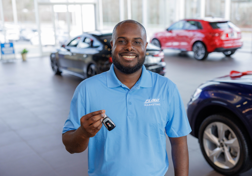 Flow employee smiling and holding a set of car keys